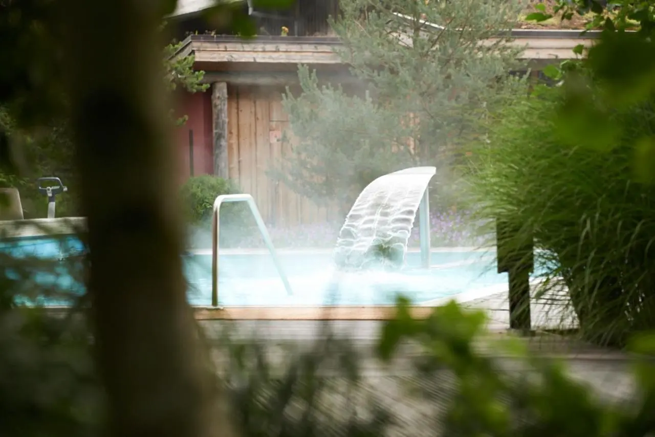Dampfendes Onsen-Becken mit Wasserfall im Spa des Bora am Bodensee