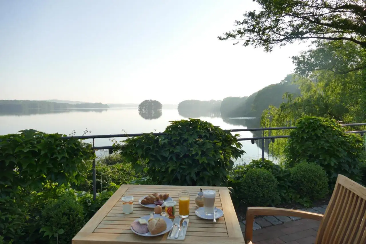 Genussurlaub im Herbst: gedeckter Frühstückstisch auf einer Terrasse über dem Bistensee im Morgenlicht